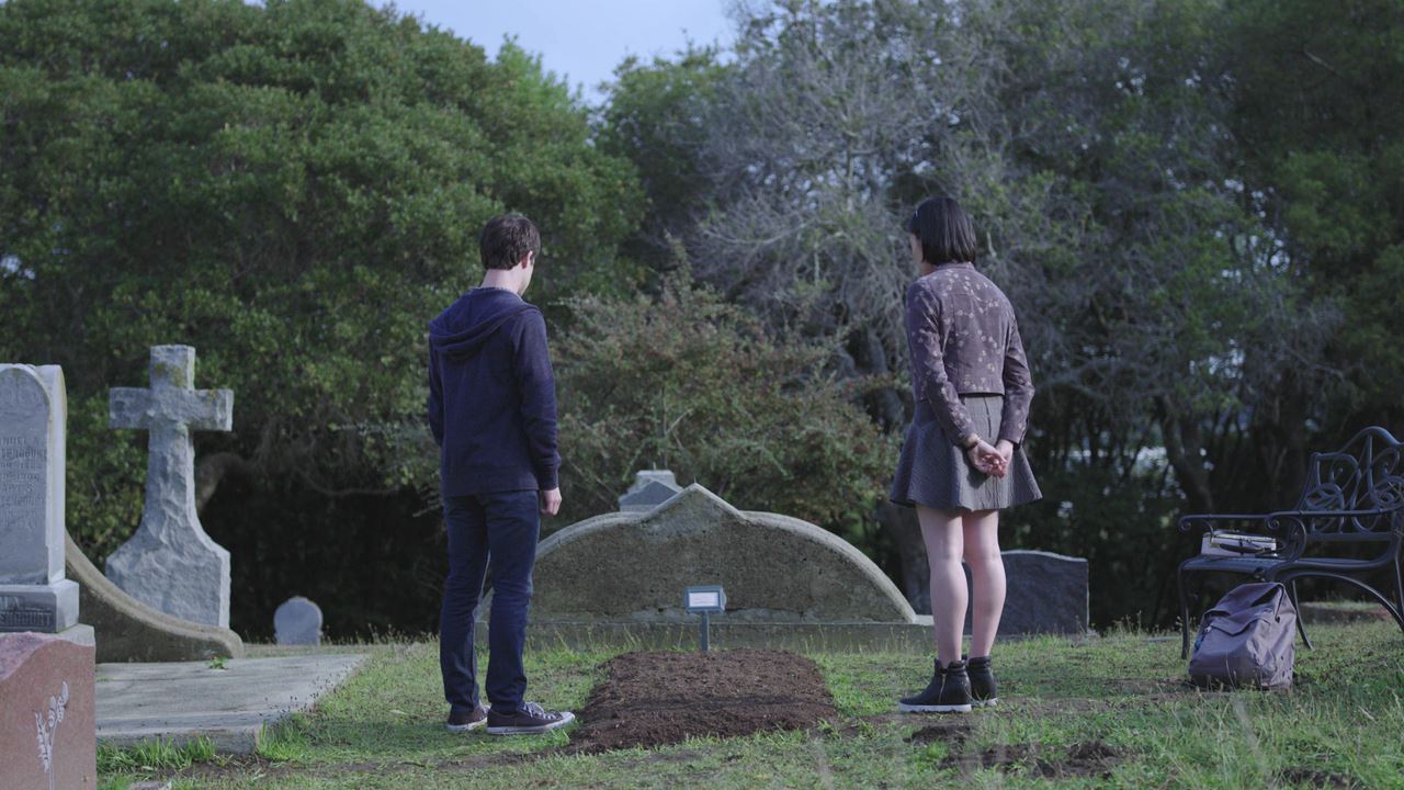 Photo of Clay beside Hannah Baker's grave