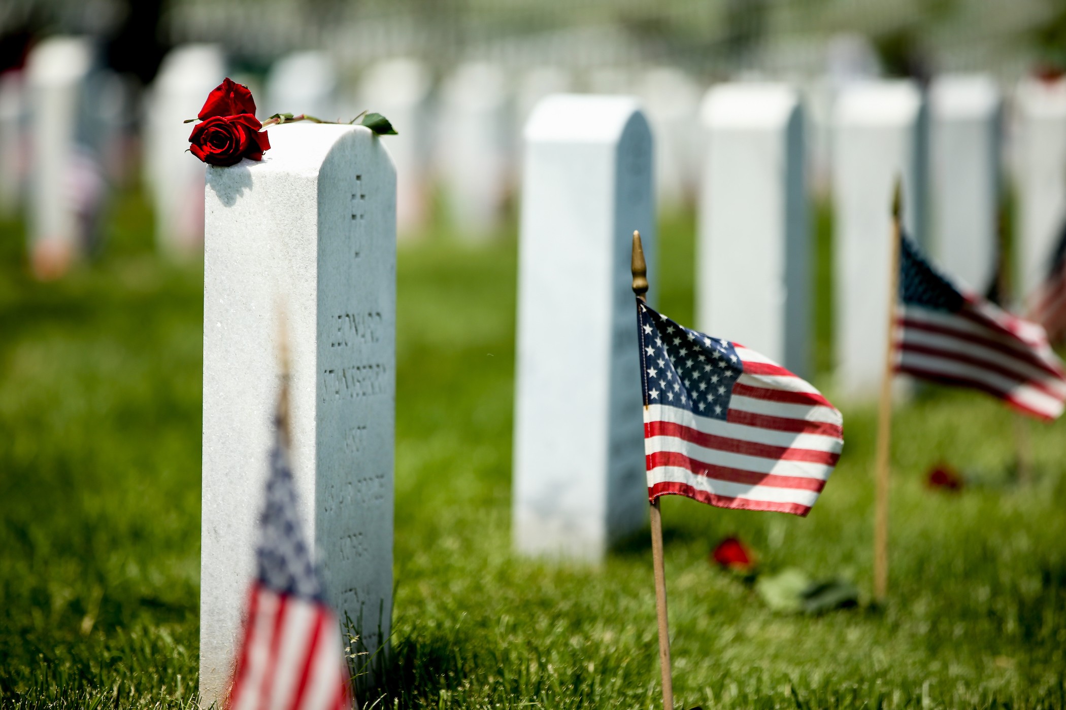 Photo of Rows of Headstones with American flag on