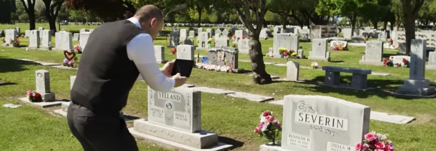 Photo of a man taking a photo of a headstone using a tablet