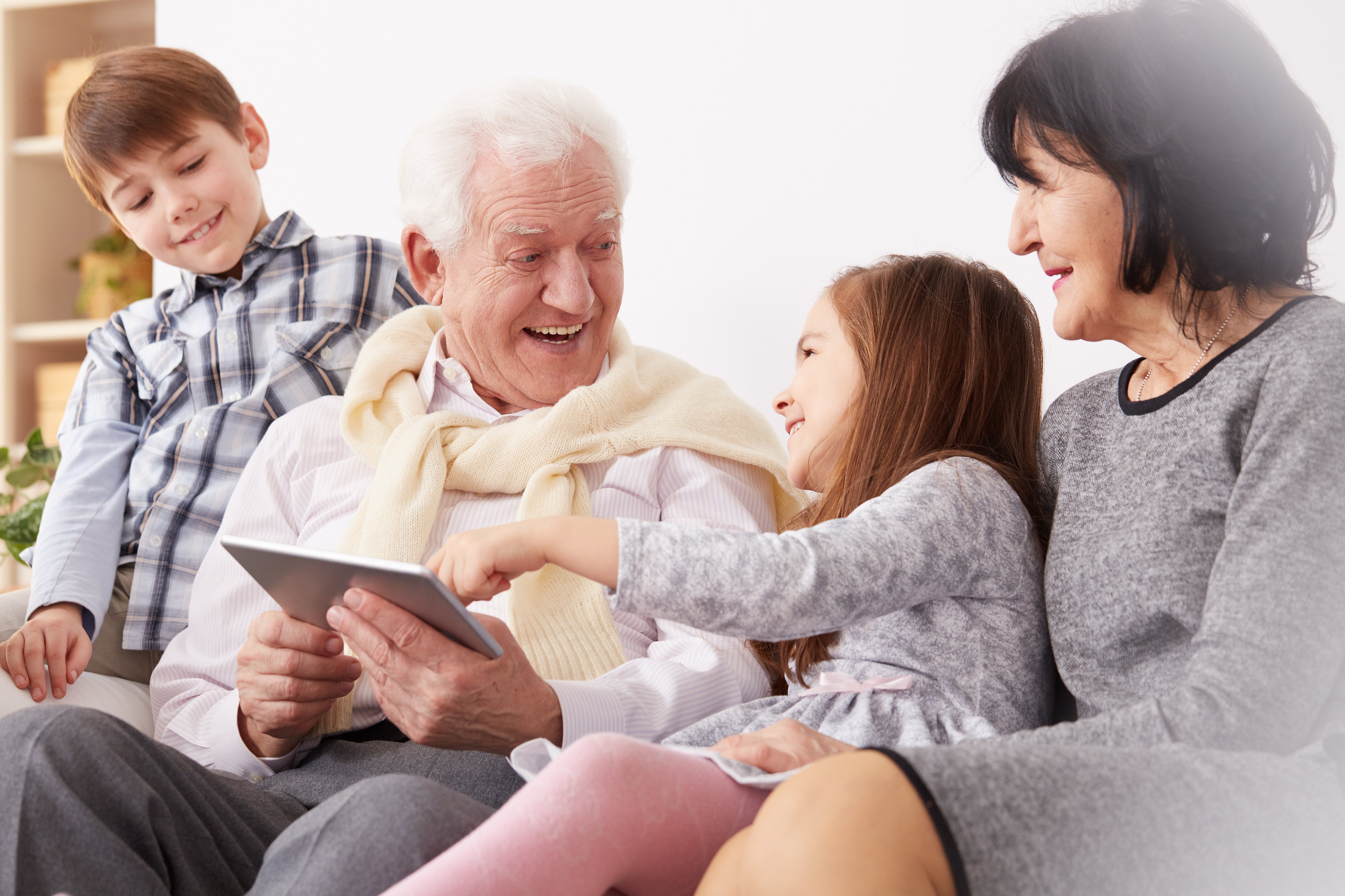 Photo of a family of multiple generations using a tablet